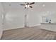 Open concept living space with light wood floors, ceiling fan, and view into the kitchen at 6160 Lowder Rd, Salisbury, NC 28147