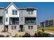 Modern townhome with gray siding, brick accents, black trim, balcony, and well-manicured landscaping at 320 Ferebee Pl # Brx0021, Charlotte, NC 28213