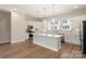 Open concept kitchen featuring white cabinets, a large island, and stainless steel appliances at 320 Ferebee Pl # Brx0021, Charlotte, NC 28213