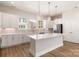 Kitchen featuring a large island with pendant lighting, white cabinets, stainless steel appliances at 320 Ferebee Pl # Brx0021, Charlotte, NC 28213