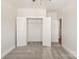 Bedroom with an open closet with white bi-fold doors, grey carpet and white trim at 312 Ferebee Pl # Brx0023, Charlotte, NC 28213