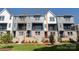 View of the townhome exterior with gray siding, brick accents, and a small front yard at 312 Ferebee Pl # Brx0023, Charlotte, NC 28213