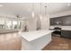 Open floor plan with a modern kitchen featuring a large island, gray cabinets, and hardwood floors at 312 Ferebee Pl # Brx0023, Charlotte, NC 28213