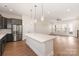Open kitchen with stainless appliances, gray cabinets, a spacious island, and an adjacent living area at 312 Ferebee Pl # Brx0023, Charlotte, NC 28213