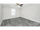 This bedroom features gray wood flooring, a ceiling fan, and natural light at 6133 Long Branch Rd, Salisbury, NC 28147