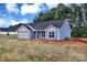 Charming single story home with blue vinyl siding, gray roof and a two-car garage in a new neighborhood at 6133 Long Branch Rd, Salisbury, NC 28147