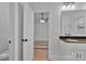 Bathroom with dark countertop sink, and an open door with a bedroom view at 6147 Long Branch Rd, Salisbury, NC 28147