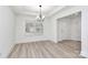 Bright dining area with wood-look floors, a modern chandelier, and a large window providing natural light at 6147 Long Branch Rd, Salisbury, NC 28147