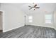 Bright bedroom with a modern ceiling fan, gray floors, and dual windows at 6155 Long Branch Rd, Salisbury, NC 28147