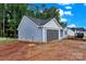 Newly constructed blue house with gray garage door surrounded by trees at 6155 Long Branch Rd, Salisbury, NC 28147