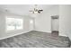 Bright open-concept living area featuring gray flooring, a ceiling fan, and a large window at 6155 Long Branch Rd, Salisbury, NC 28147