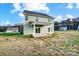 Backyard featuring a covered patio, green lawn, and view of neighboring homes and trees at 11507 Valley Oaks Ln, Stanfield, NC 28163