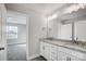 Bathroom with double vanity, granite counters, white cabinets, and door to an additional room at 11507 Valley Oaks Ln, Stanfield, NC 28163