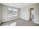 Bright bedroom featuring neutral walls, carpet, and a large window offering a view of the yard at 11507 Valley Oaks Ln, Stanfield, NC 28163