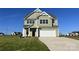 Inviting two-story home featuring a spacious driveway, a two-car garage, and a beautifully landscaped lawn at 11507 Valley Oaks Ln, Stanfield, NC 28163