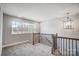 Bright hallway featuring carpet flooring, decorative lighting, and a window with view of the backyard at 11507 Valley Oaks Ln, Stanfield, NC 28163