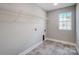 A compact laundry room includes a wire shelf above hookups and modern flooring at 11507 Valley Oaks Ln, Stanfield, NC 28163