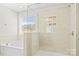 Bright bathroom featuring a soaking tub, glass-enclosed shower and a large window with natural light at 3023 Spinner Ct, Denver, NC 28037