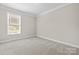 Bright bedroom features neutral carpet, white base molding, and a large window at 3023 Spinner Ct, Denver, NC 28037