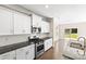 Modern kitchen design includes white cabinets, stainless steel appliances, and granite countertops at 3023 Spinner Ct, Denver, NC 28037