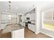 Bright kitchen with granite island, white cabinets, stainless steel appliances, and hardwood floors at 3023 Spinner Ct, Denver, NC 28037