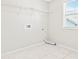 Bright laundry room with tiled floors, washer and dryer hookups and storage shelving at 3023 Spinner Ct, Denver, NC 28037