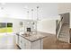 Open concept living area with kitchen island, fireplace, hardwood flooring, and natural light at 3023 Spinner Ct, Denver, NC 28037