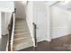 View of a carpeted stairway with a wooden banister and dark wood floors at 3023 Spinner Ct, Denver, NC 28037