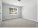 Cozy bedroom showcasing neutral walls, carpet and a window with a view of the outdoors at 2016 Cedar Falls Dr # 7, Waxhaw, NC 28173