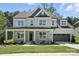 Charming two-story home featuring a covered front porch, manicured lawn, and attached two-car garage at 2016 Cedar Falls Dr # 7, Waxhaw, NC 28173