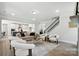 Open-concept living room showcases a staircase, flows into the kitchen and has modern decor at 2016 Cedar Falls Dr # 7, Waxhaw, NC 28173