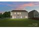 Spacious backyard with lush green lawn and vinyl siding home at sunset at 14447 Waterlyn Dr, Charlotte, NC 28278