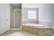This bathroom features a shower and a tub with neutral colors at 14447 Waterlyn Dr, Charlotte, NC 28278