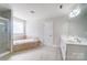 This bathroom features a shower, tub, double vanity, and light tile at 14447 Waterlyn Dr, Charlotte, NC 28278