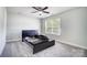 A bright bedroom offers neutral walls and carpet with a bed frame plus one large window at 14447 Waterlyn Dr, Charlotte, NC 28278