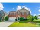 Inviting two-story brick home with green shutters and lush green lawn under a partly cloudy sky at 14447 Waterlyn Dr, Charlotte, NC 28278