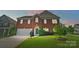 Charming brick front home with green door, two-car garage and landscaped yard at 14447 Waterlyn Dr, Charlotte, NC 28278
