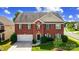 Charming two-story brick home featuring green shutters and a well-manicured front lawn at 14447 Waterlyn Dr, Charlotte, NC 28278