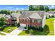 Aerial view of a brick two-story home with a two-car garage and green lawn at 14447 Waterlyn Dr, Charlotte, NC 28278