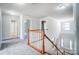 Bright hallway with wood and white railing and chandelier in the background at 14447 Waterlyn Dr, Charlotte, NC 28278