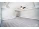 A large main bedroom features neutral walls and carpeting, a ceiling fan, and plenty of natural light at 14447 Waterlyn Dr, Charlotte, NC 28278