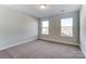 A cozy bedroom has carpet and two windows at 130 Summerhill Dr # 16, Mooresville, NC 28115