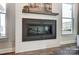 Close-up of a sleek, modern fireplace with decorative art above and natural light streaming in at 130 Summerhill Dr # 16, Mooresville, NC 28115