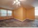 Spacious bedroom with gray carpet and yellow walls, featuring two windows at 5237 Nc Highway 90 E Hwy, Hiddenite, NC 28636