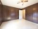 Bedroom featuring ceiling fan, wood paneled walls, and light colored floor at 553 Georgia Ave, Statesville, NC 28677