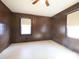 Bedroom featuring ceiling fan, wood paneled walls, and light colored floor at 553 Georgia Ave, Statesville, NC 28677