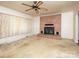 Spacious living room featuring a brick fireplace and a decorative ceiling fan at 553 Georgia Ave, Statesville, NC 28677