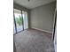 This is an empty bedroom with neutral walls, soft carpet, and sliding glass doors to a balcony at 701 Royal Ct # 309, Charlotte, NC 28202