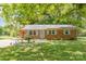 Brick ranch house with light blue shutters, landscaping, and a covered porch at 621 Oak Grove Rd, Kings Mountain, NC 28086