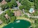 Aerial view of complex featuring a pond, swimming pool, and mature landscaping on a sunny day at 7378 Winery Ln, Charlotte, NC 28227